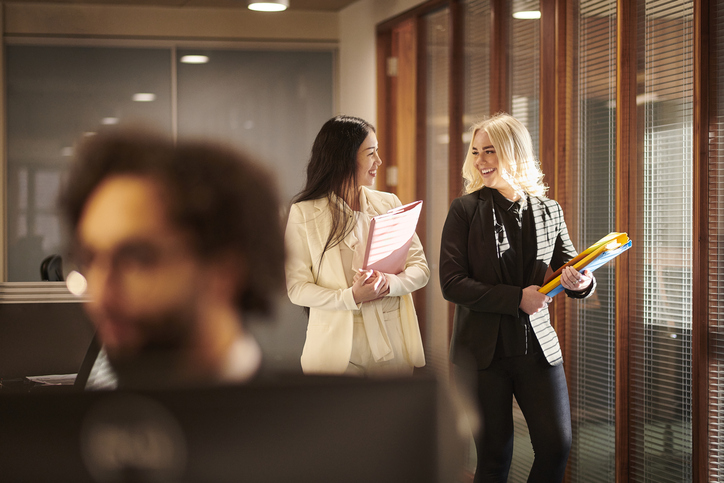 | Paralegal organizing expert witness case files and legal documents at desk in law office