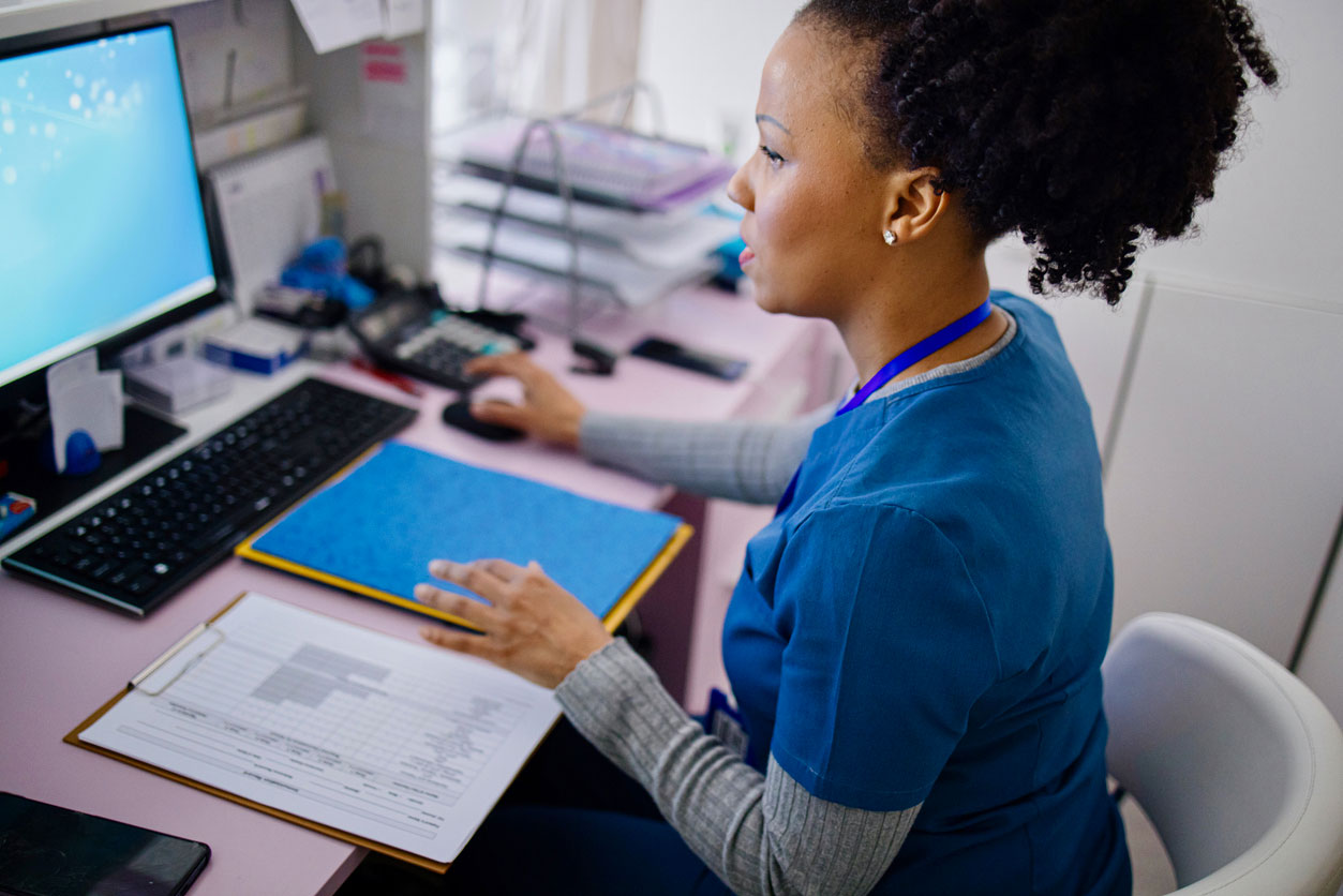 Nurse paralegal analyzing medical malpractice case files while reviewing patient charts in legal office